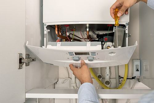 Heating technician repairing a residential boiler in Stockton