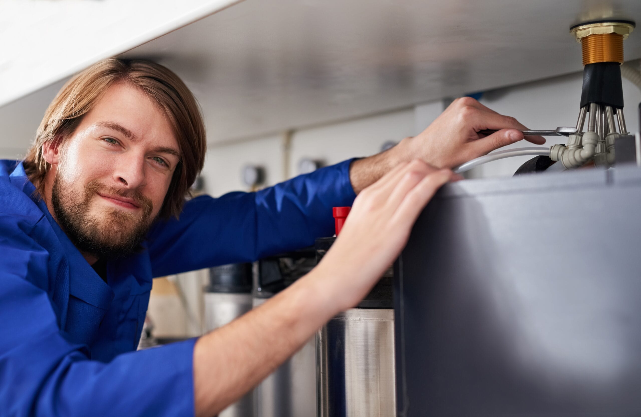 Technician servicing a residential water heater tank in Stockton